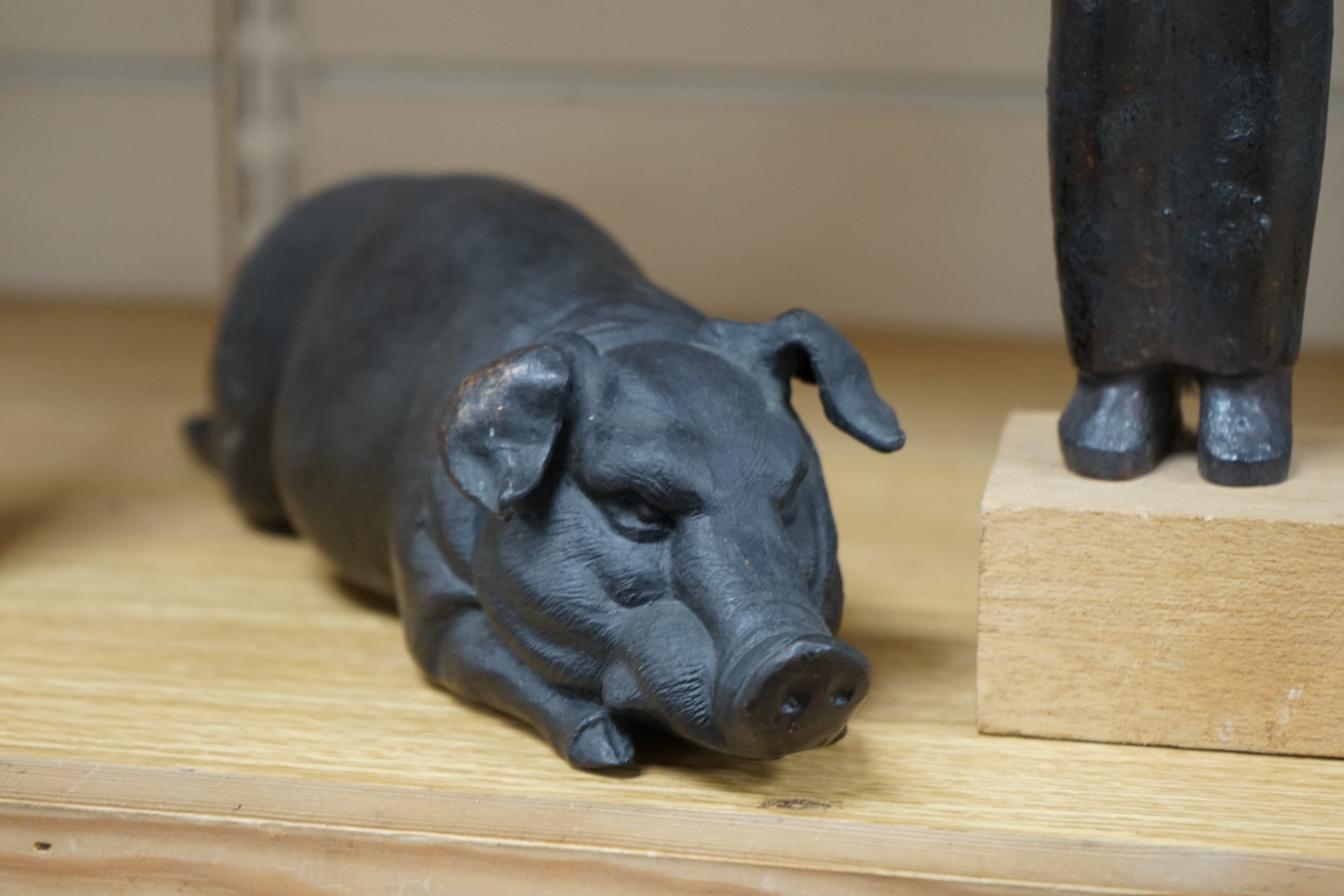 A bronze model of a recumbent pig, another cast iron model of twin heads and bronze maquette of a figure, in the style of Henry Moore, 31cm (3). Condition - good